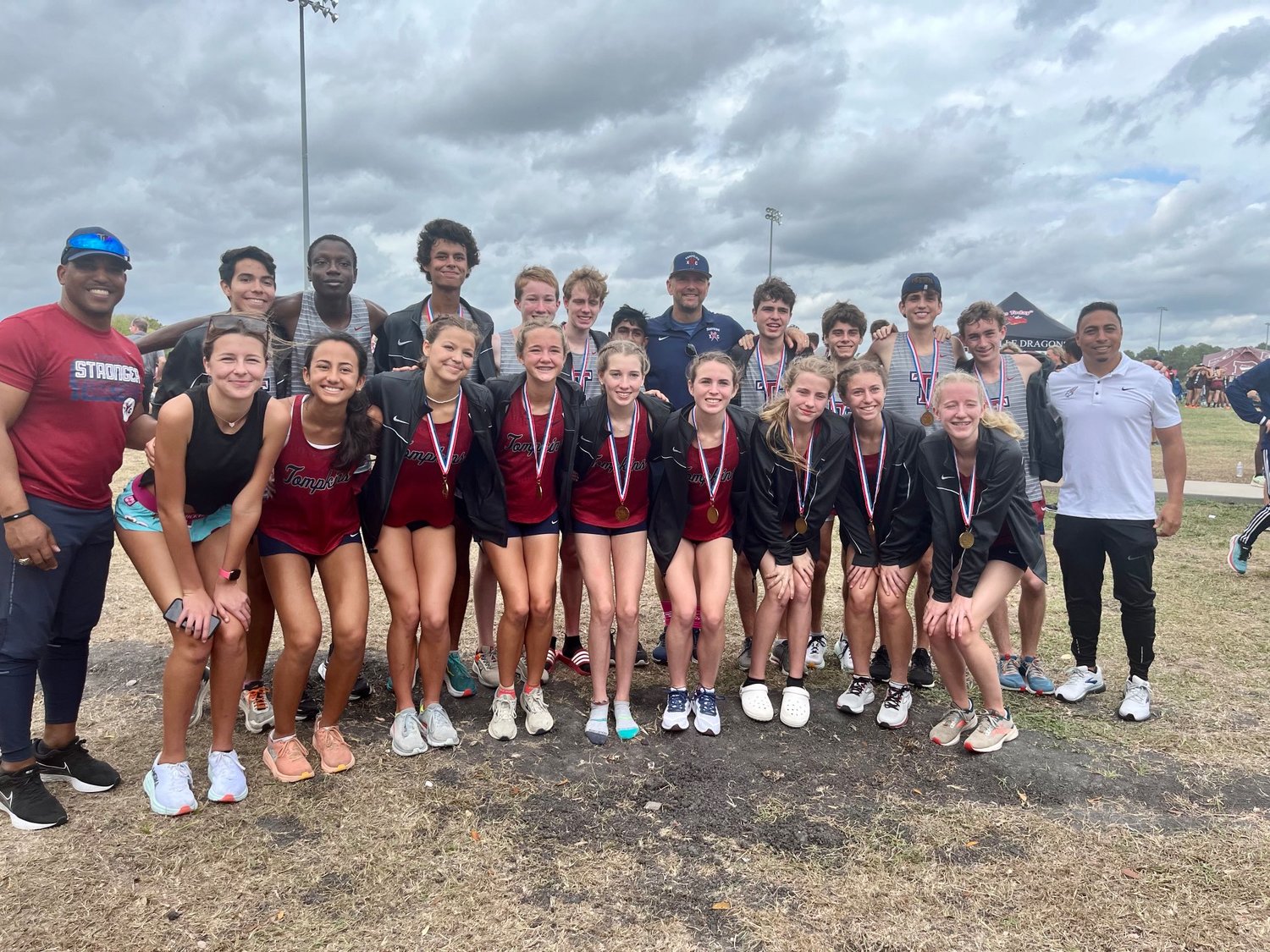 The Tompkins boys and girls teams pose together after both qualified for the state cross country meet on Monday.
